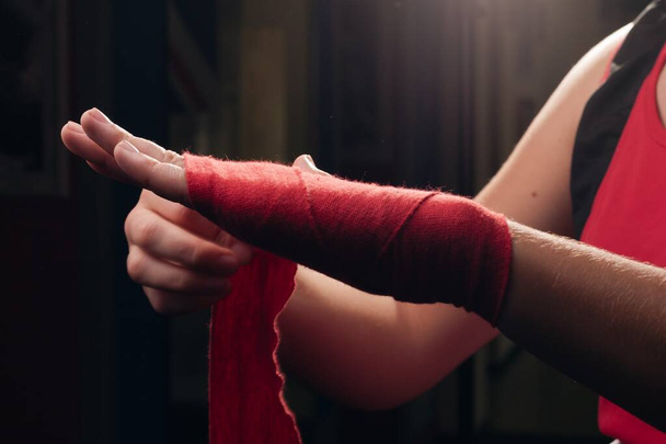 Boxeador chica en rojo bandas de boxeo de cerca. - Foto, Imagen
