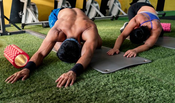 man and woman in gym doing abs - Photo, Image