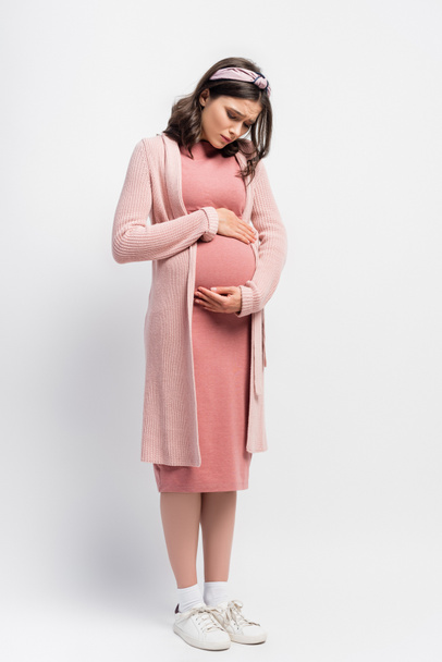 donna incinta in fascia toccare pancia pur avendo crampi sul bianco - Foto, immagini