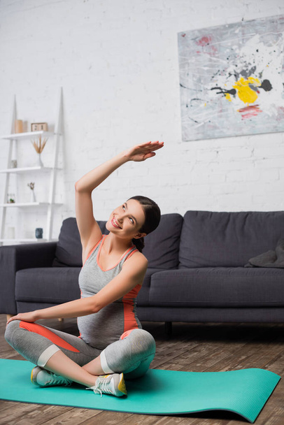 joyful pregnant woman exercising on fitness mat at home - Zdjęcie, obraz
