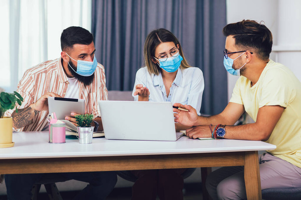 Students studies at home, wear protective masks, and using laptop - Φωτογραφία, εικόνα
