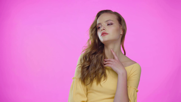 fiatal nő pózol, megható arc és haj elszigetelt rózsaszín - Felvétel, videó