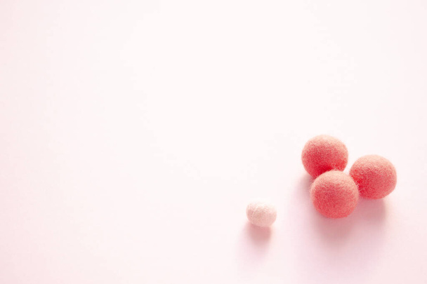 Pile de boules de laine de feutre au sommet de la surface tachetée rose. Fait à la main pour les passe-temps ou les perles pour les bijoux ou accessoires. - Photo, image