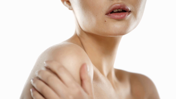 Cropped view of young woman applying lotion on shoulder isolated on white - Footage, Video