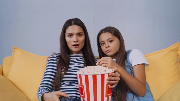 bambino mangiare popcorn e guardare film con la madre  - Filmati, video