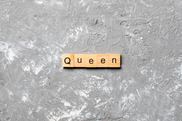 Königin Wort auf Holzblock geschrieben. Queen Text auf Zementtisch für Ihre Gestaltung, Konzept. - Foto, Bild