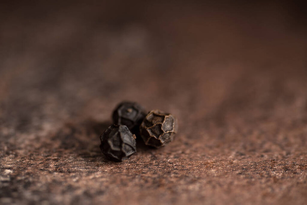 Close up of black pepper or peppercorns on a stone background. - Foto, Bild