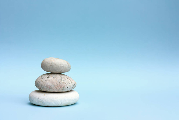 Árbol de piedras redondas grises sobre fondo de color pastel azul claro. Piedras de spa, zen como concepto - Foto, Imagen