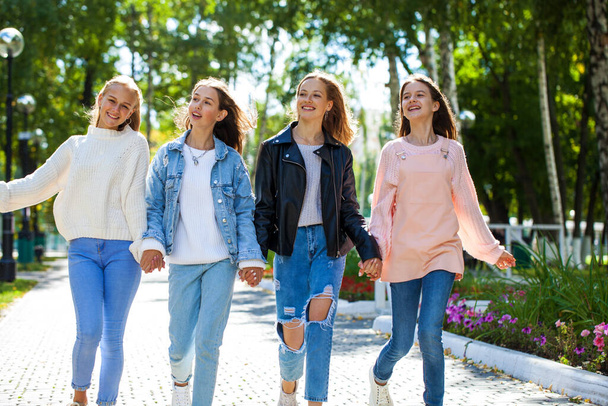 Four happy young girls walking in autumn park - Фото, зображення