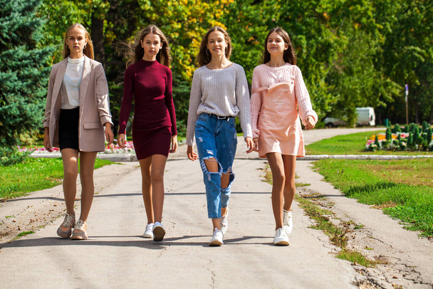 Four happy young girls walking in autumn park - Fotoğraf, Görsel
