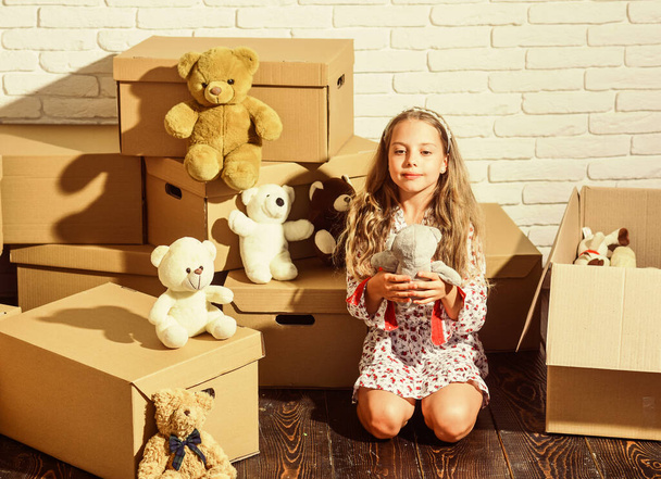 Live the uptown urban lifestyle. purchase of new habitation. happy little girl with toy. happy child cardboard box. Cardboard boxes - moving to new house. playing into new home. new apartment - Foto, afbeelding