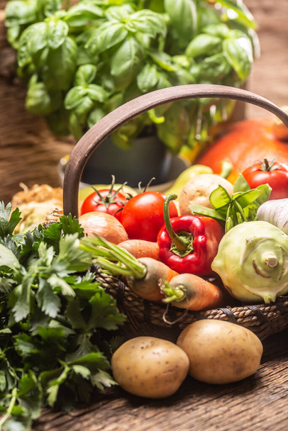 Selection of autumn fresh harvest of vegetables on a vintage wooden surface and inside a basket. - Photo, image