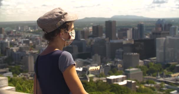 Γυναίκα φορώντας μάσκα κοιτάζοντας το όμορφο παρατηρητήριο της πόλης - Πλάνα, βίντεο