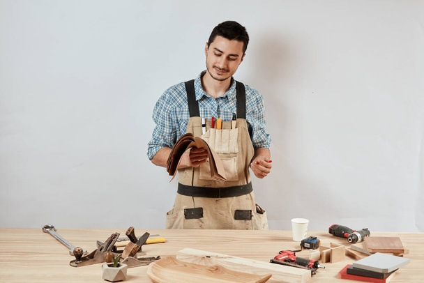 Cheerful pleasant bearded joiner at work at his workshop - Fotó, kép