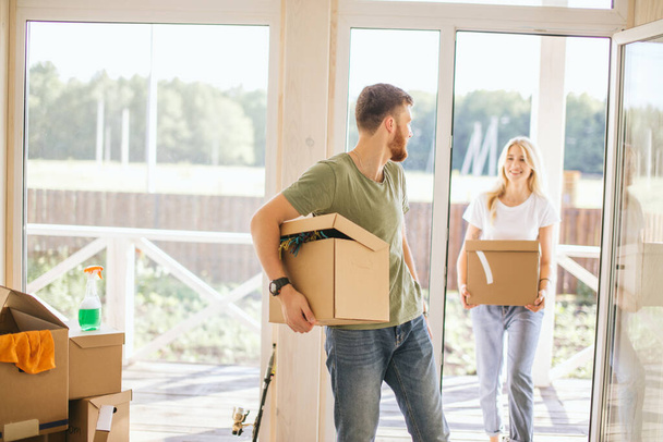 Happy Couple Carrying Cardboard Boxes Into New Home On Moving Day - Fotoğraf, Görsel