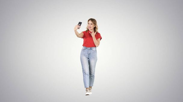Cute sexy girl with blond curly hair walking and making selfie o - Zdjęcie, obraz
