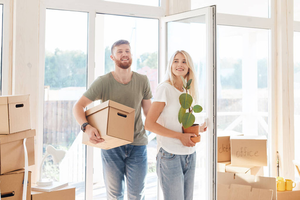 Ευτυχισμένο ζευγάρι που μεταφέρουν χαρτονένια κουτιά σε νέο σπίτι για την ημέρα που κινείται - Φωτογραφία, εικόνα