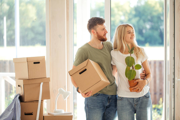 Happy Couple Carrying Cardboard Boxes Into New Home On Moving Day - Photo, image
