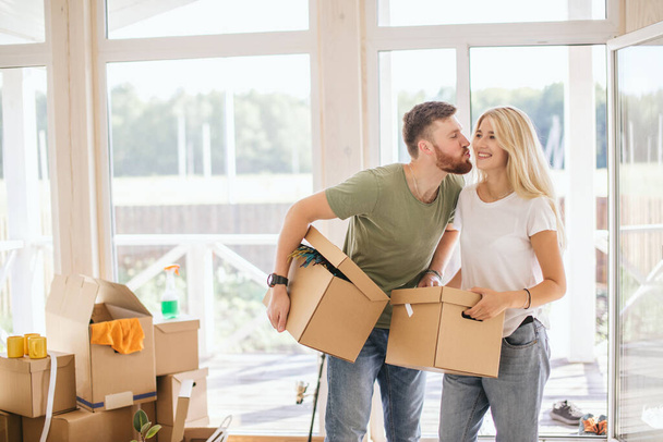 Happy Couple Carrying Cardboard Boxes Into New Home On Moving Day - Foto, immagini