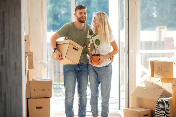 Ευτυχισμένο ζευγάρι που μεταφέρουν χαρτονένια κουτιά σε νέο σπίτι για την ημέρα που κινείται - Φωτογραφία, εικόνα