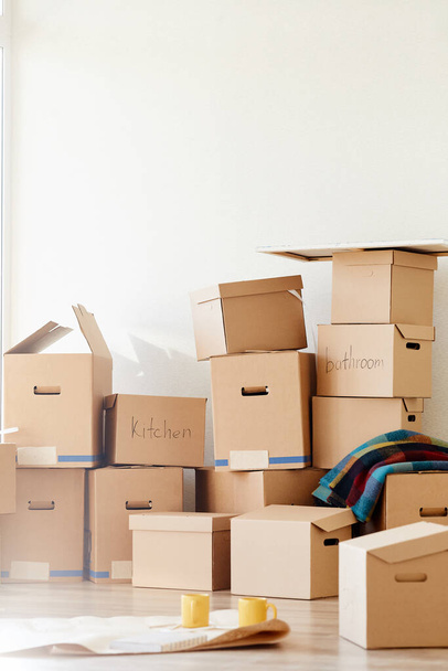 Stack of cardboard boxes in room of new home - 写真・画像