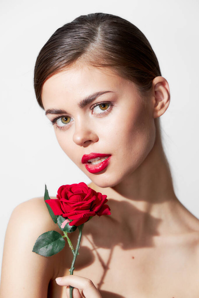 Kobieta z czerwonym kwiatem gołe ramiona czysty luksus skóra czerwone usta  - Zdjęcie, obraz