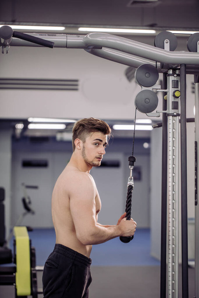 bodybuilder performing exercise with gym training mashine - 写真・画像