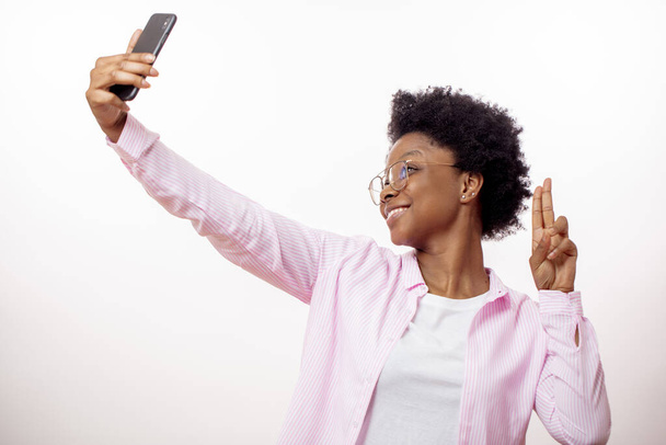 awesome positive hipster girl showing victory sign while making selfie - Foto, immagini