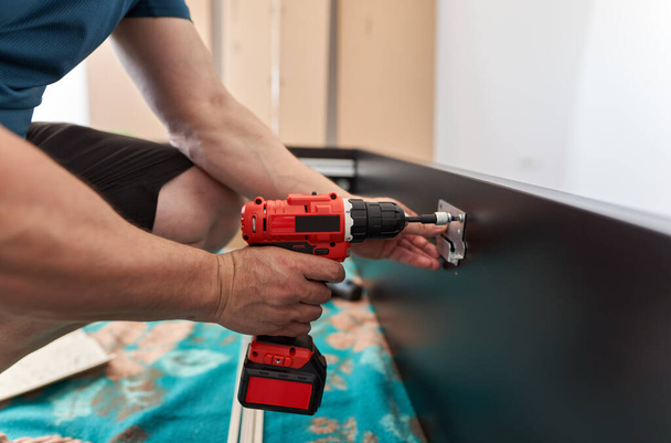 Man assembling his new furniture when moving house - 写真・画像
