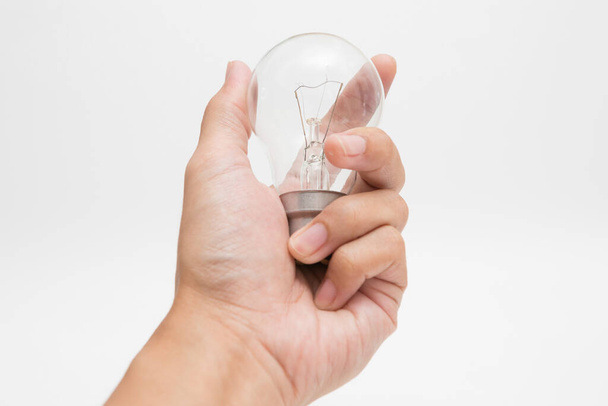 Mão segurando uma lâmpada de tungstênio no fundo branco - Foto, Imagem