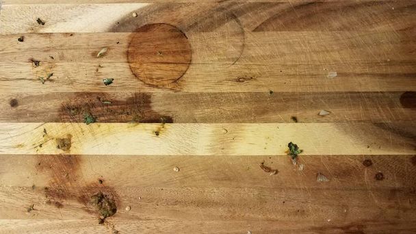 брудна дерев'яна обробна дошка з шматочками їжі та круглою плямою
 - Фото, зображення