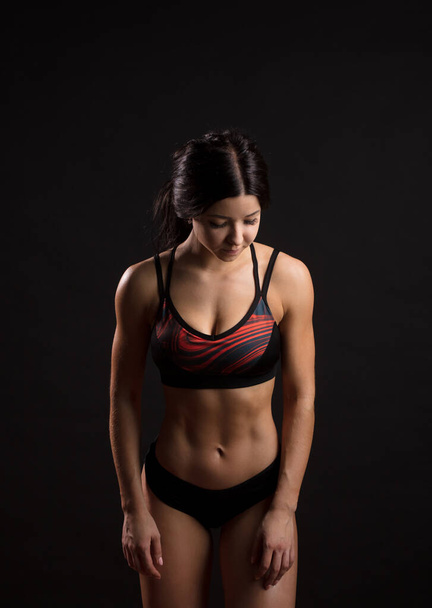 Sportswoman with ripped abs in black sportswear. Miss fitness bikini. - Fotó, kép