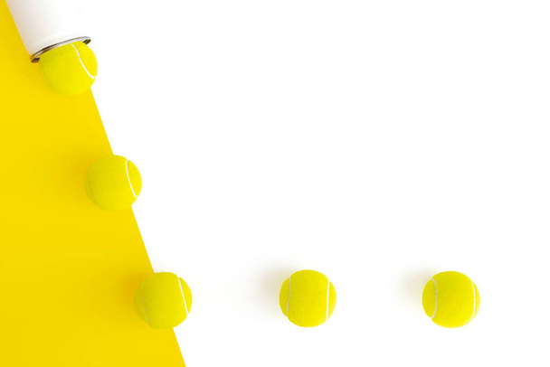 Тенісні м'ячі ізольовані на геометричному білому і жовтому тлі. Творча спортивна концепція. Розкладка з пробілом для копіювання тексту. Вид зверху, мінімальна плоска поверхня
. - Фото, зображення
