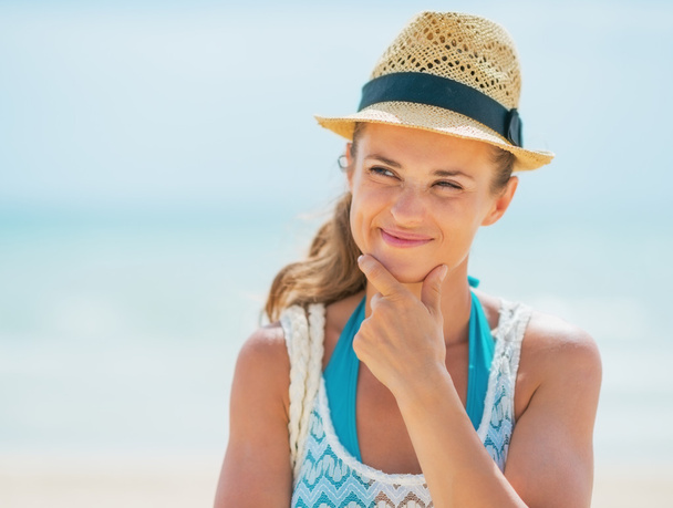 Thoughtful young woman in hat on beach - Φωτογραφία, εικόνα