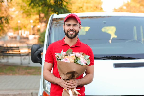Доставка чоловіка з букетом красивих квітів біля автомобіля на відкритому повітрі
 - Фото, зображення