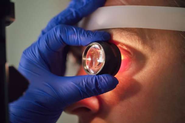 Um oftalmologista verifica o fundo do paciente. - Foto, Imagem