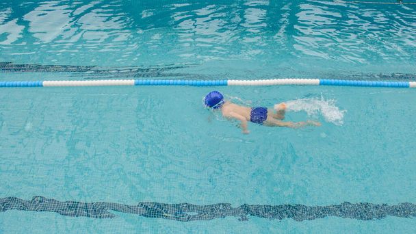 7歳の男の子がプールで遊んだり泳いだり - 写真・画像
