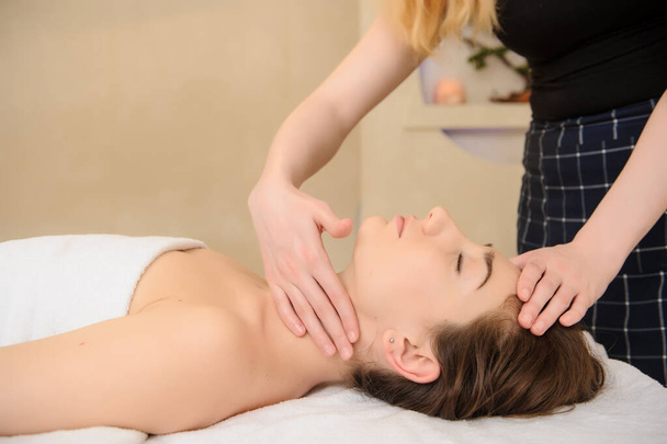giovane donna che fa un massaggio sul collo nel salone spa - Foto, immagini