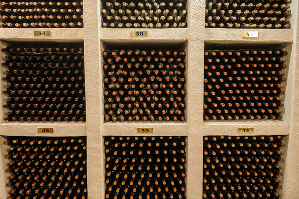  Винные бутылки, сложенные в старом винном погребе - Фото, изображение