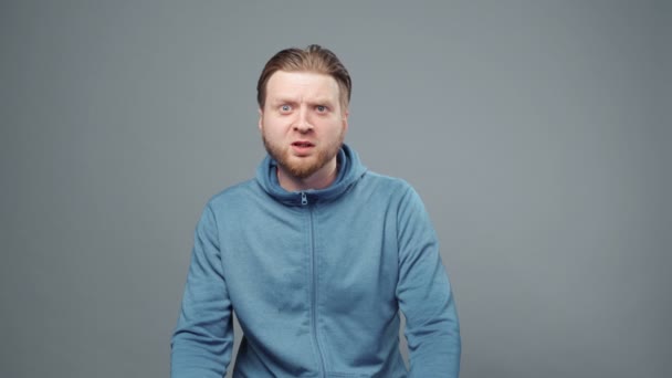 Video von verängstigtem blonden Mann im blauen Sweatshirt - Filmmaterial, Video