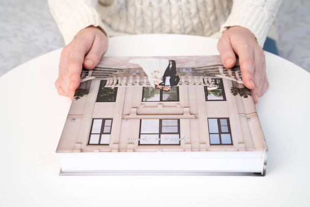 women's hands hold a wedding photo book - Foto, imagen