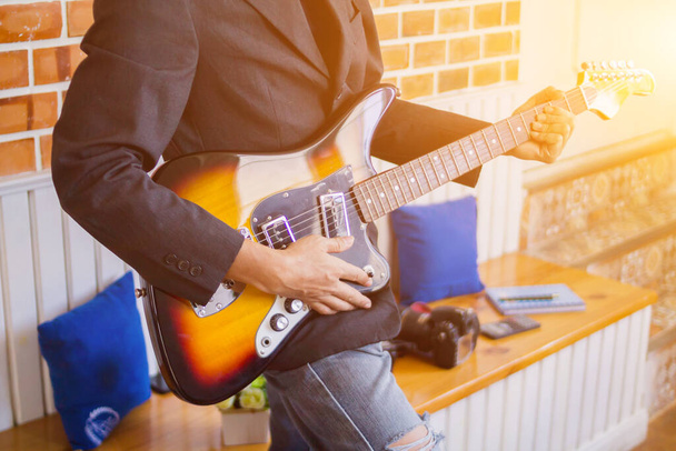 Soft & Smooth Focus, οι μουσικοί παίζουν κιθάρα σε ένα δωμάτιο μουσικής εξάσκησης σε ένα νυχτερινό κέντρο διασκέδασης για να προετοιμαστούν πριν εκτελέσουν το Guitar Classic κατά τη διάρκεια της βραδιάς. Επαγγελματική ιδέα άσκησης κιθάρας - Φωτογραφία, εικόνα