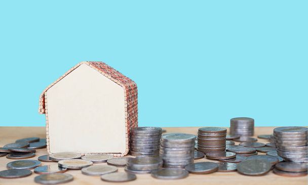 future saving money for 2021 year concept. coin with model house on wood with blue background. article for buy house for cash nex year. - Photo, Image