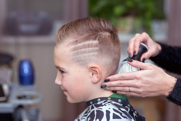 Vue latérale Nice garçon européen obtenir coiffure dans barbershop.hairdresser fait une coiffure pour un garçon - Photo, image