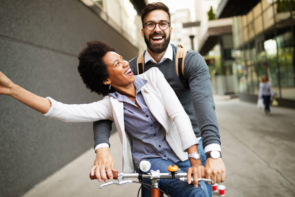 Young happy couple having fun in the city and ride a bicycle - Photo, image