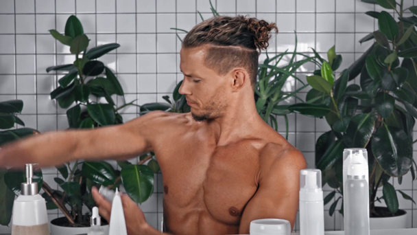 Man using deodorant in bathroom - Πλάνα, βίντεο