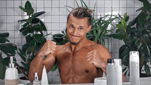 Mann zeigt Fäuste und zeigt mit Fingern auf Badezimmer - Filmmaterial, Video