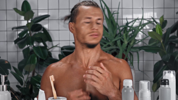 Mann sieht Falten an und macht Fratzen im Badezimmer - Filmmaterial, Video