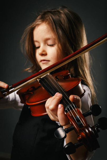 Schöne Mädchen mit langen Haaren und geschlossenen Augen spielen auf der Geige - Foto, Bild