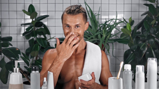 Άνδρας εφαρμογή κρέμα προσώπου στο μπάνιο - Πλάνα, βίντεο